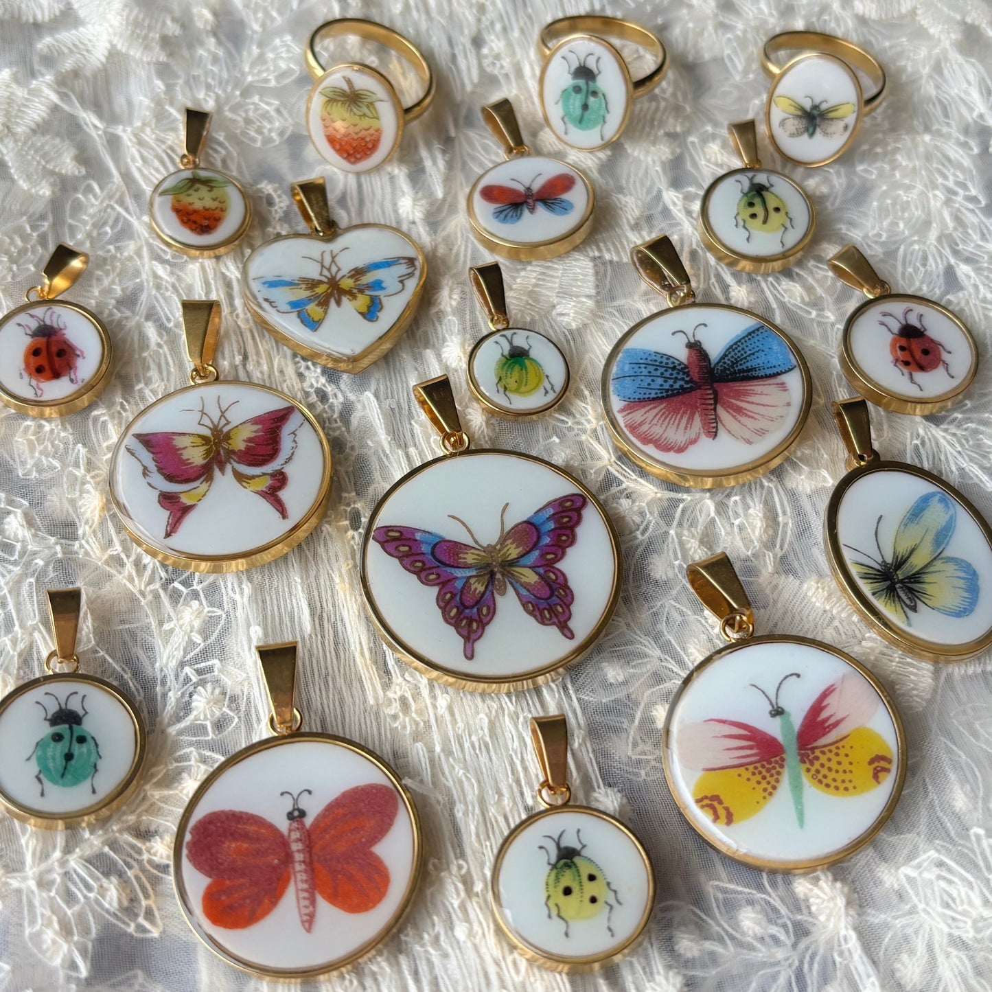Collection of butterfly-themed pendants on a textured white background