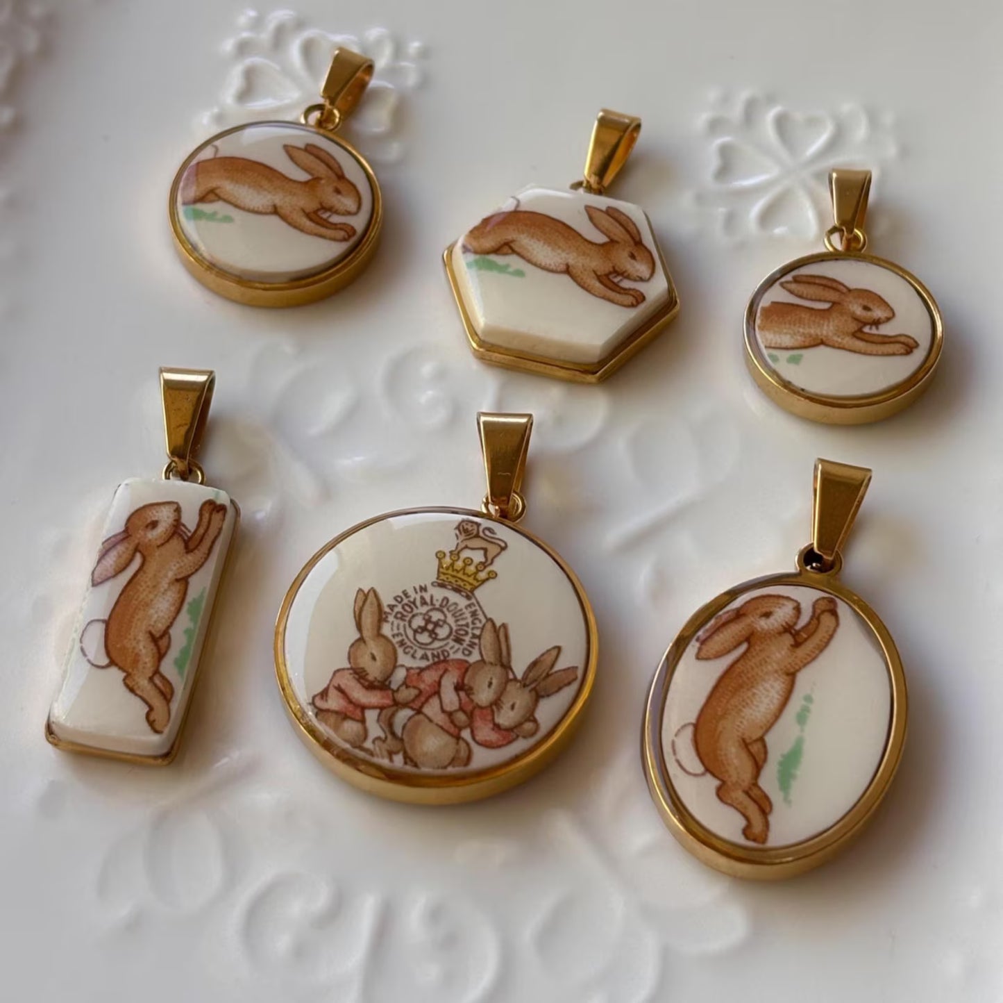 Set of rabbit-themed pendants on a textured white background