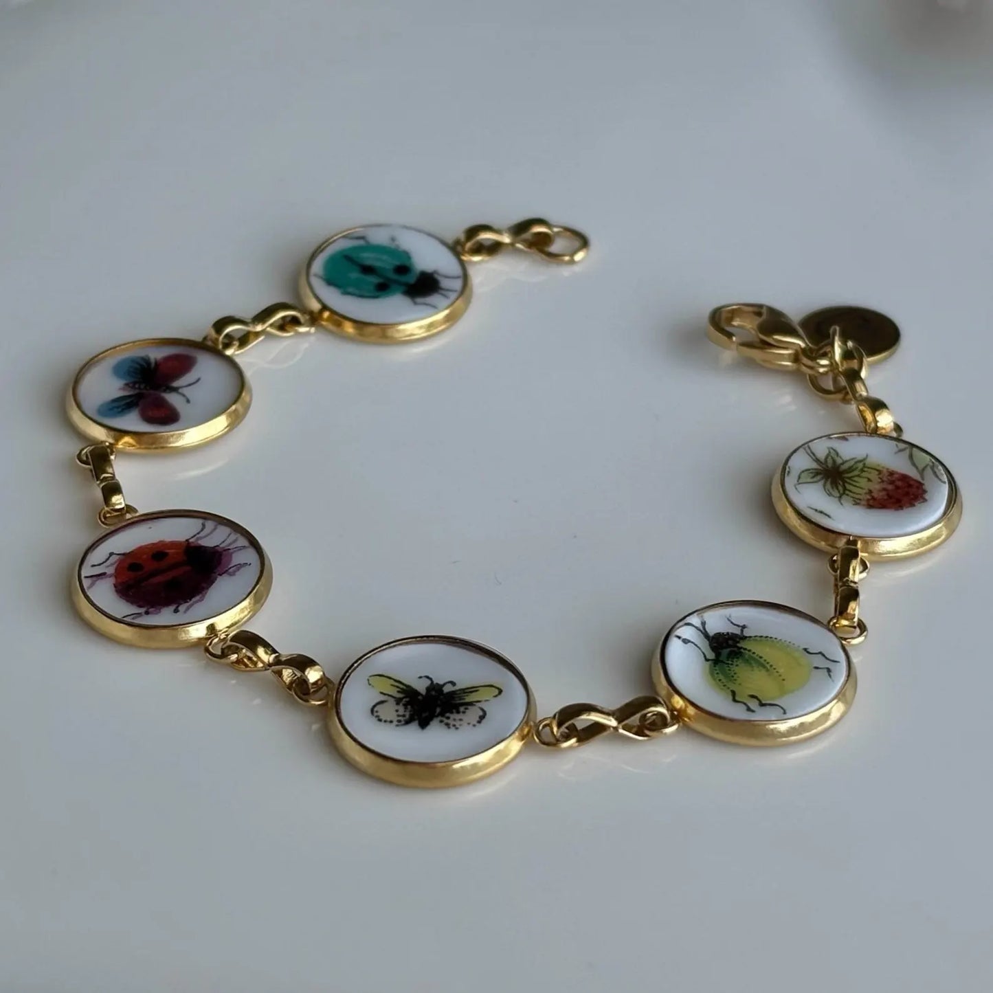 Bracelet with insect-themed charms on a white background