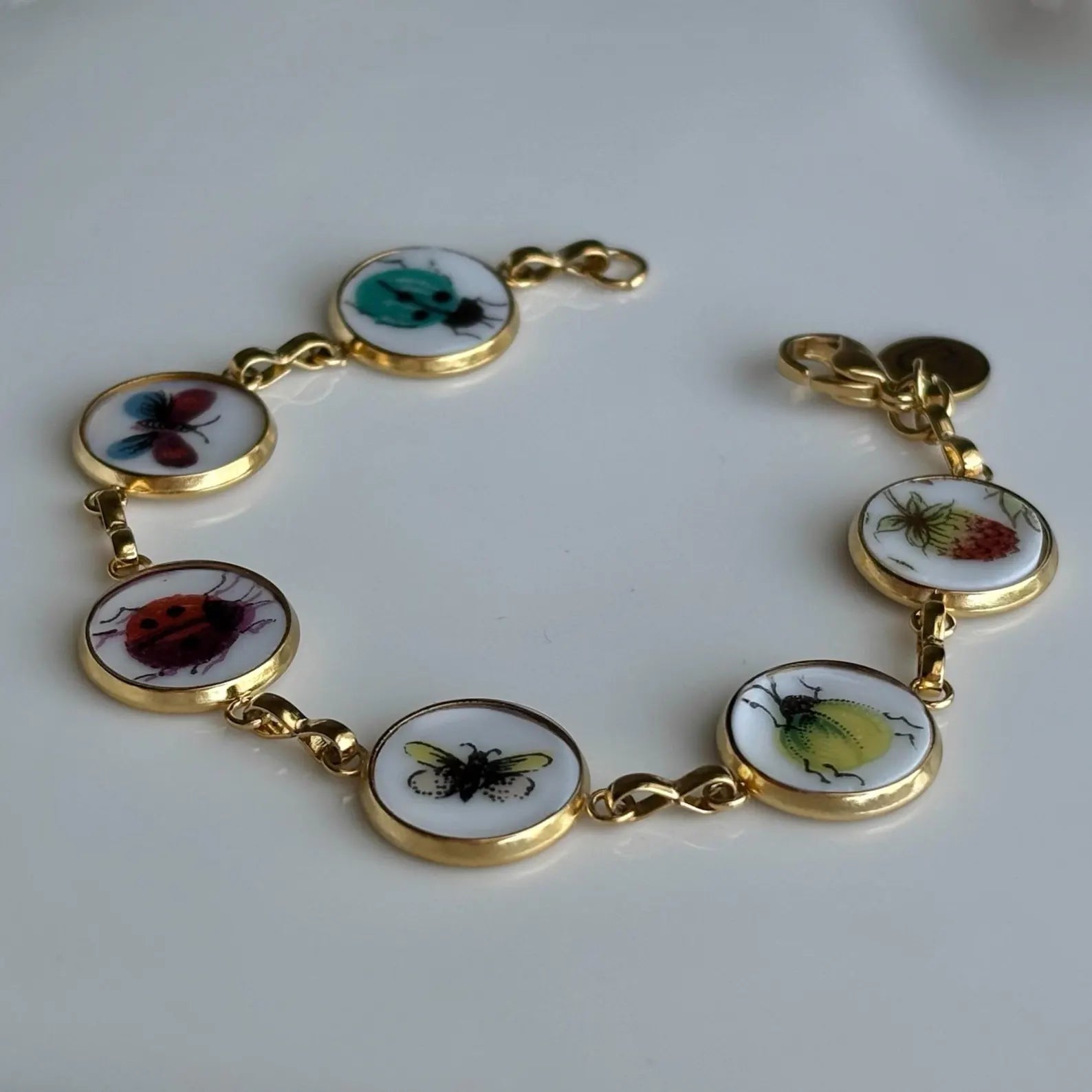 Bracelet with insect-themed charms on a white background