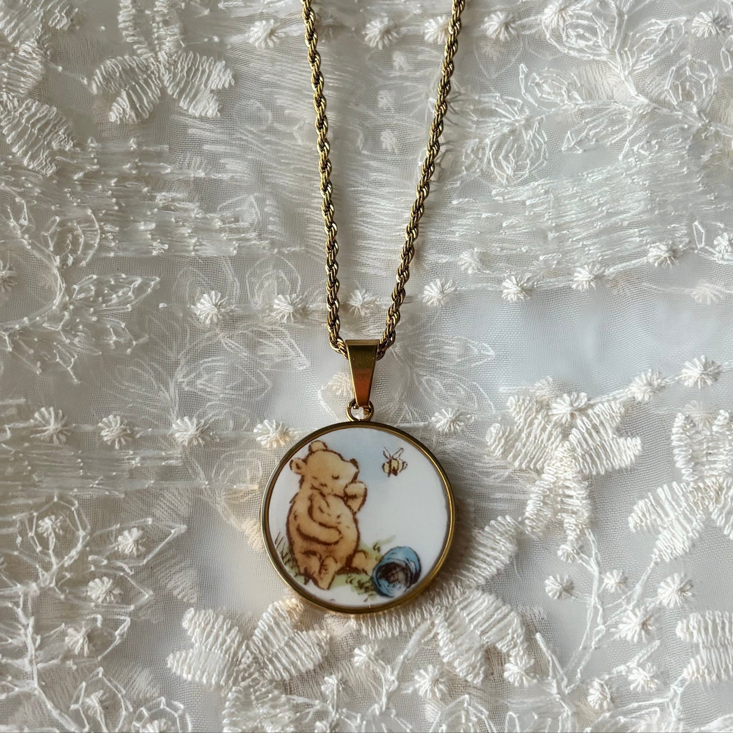 Necklace with a pendant featuring a bear design on a textured white background
