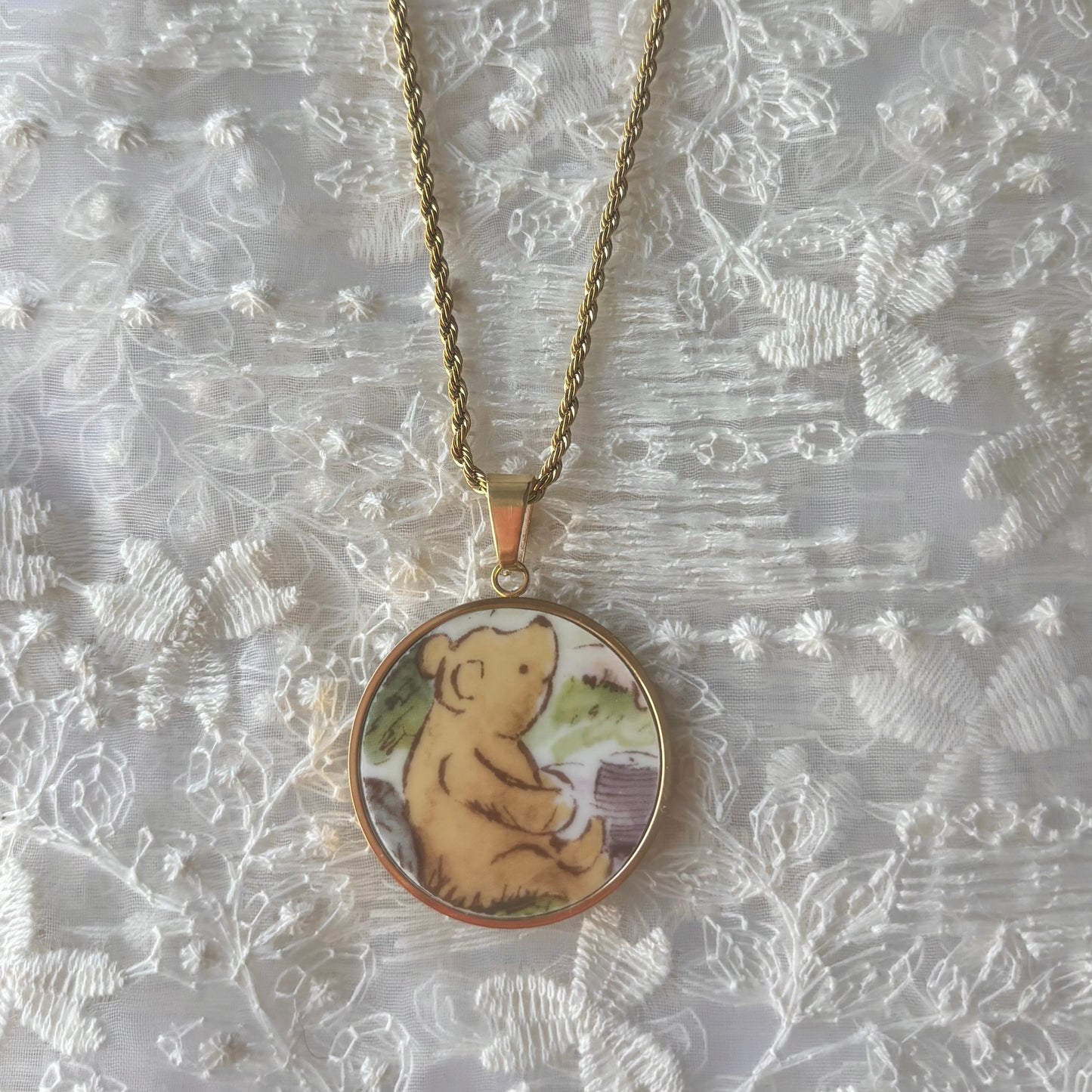 Necklace with a pendant featuring a bear design on a textured white background