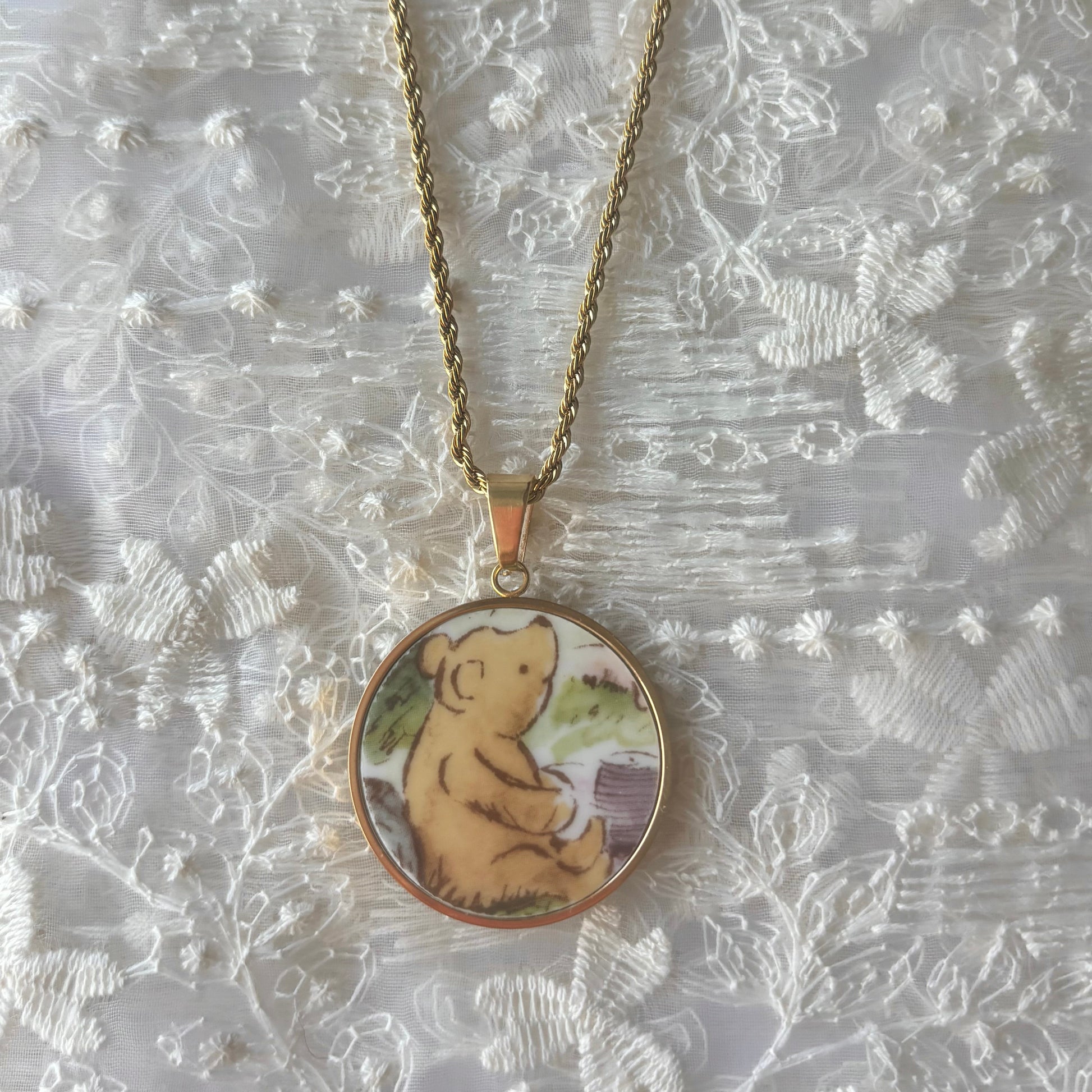 Necklace with a pendant featuring a bear design on a textured white background
