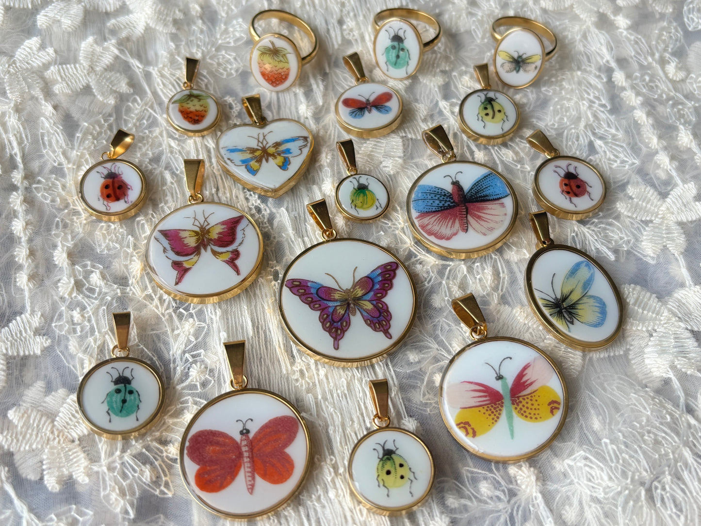 Collection of butterfly-themed pendants on a textured white background