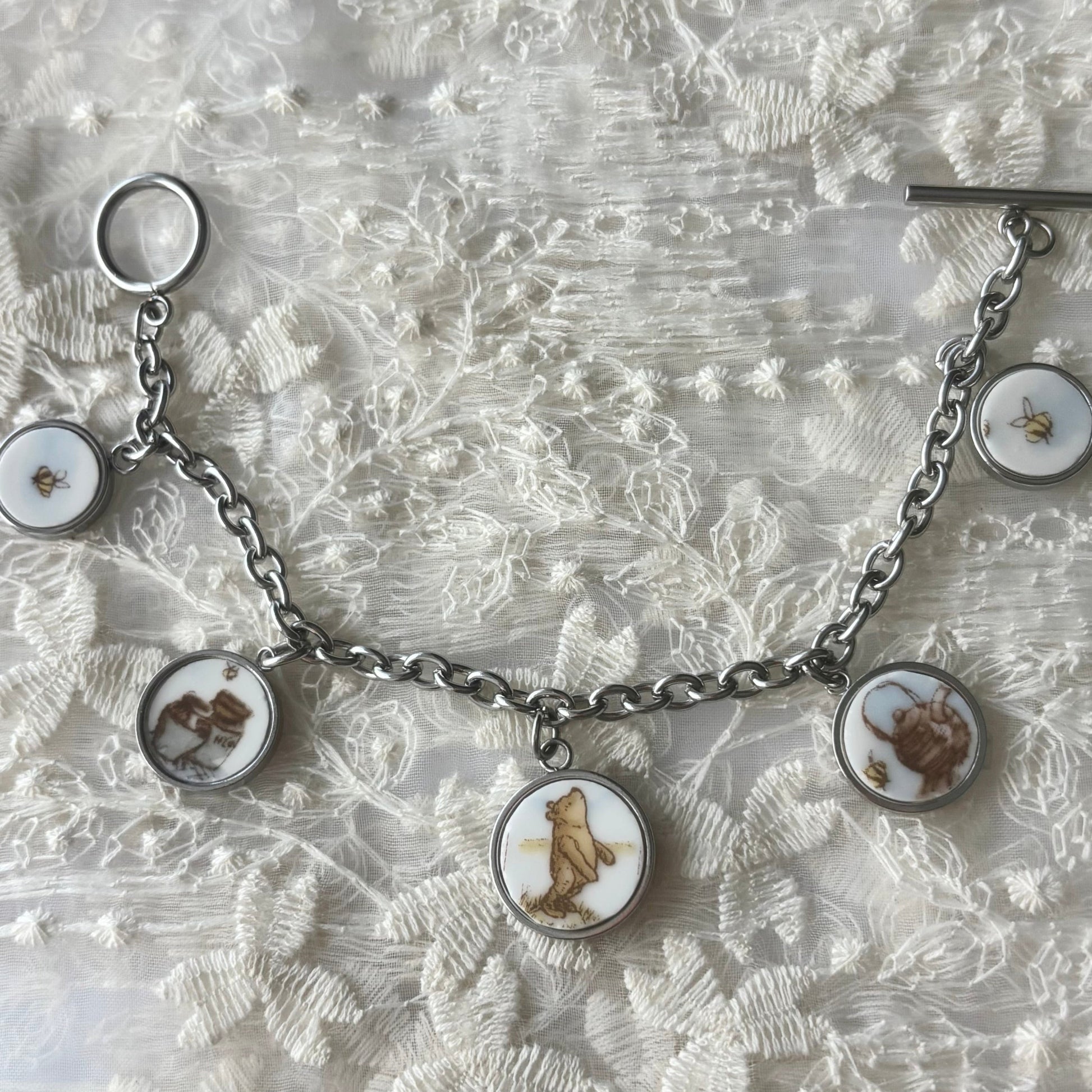 Bracelet with bear-themed charms on a textured white background