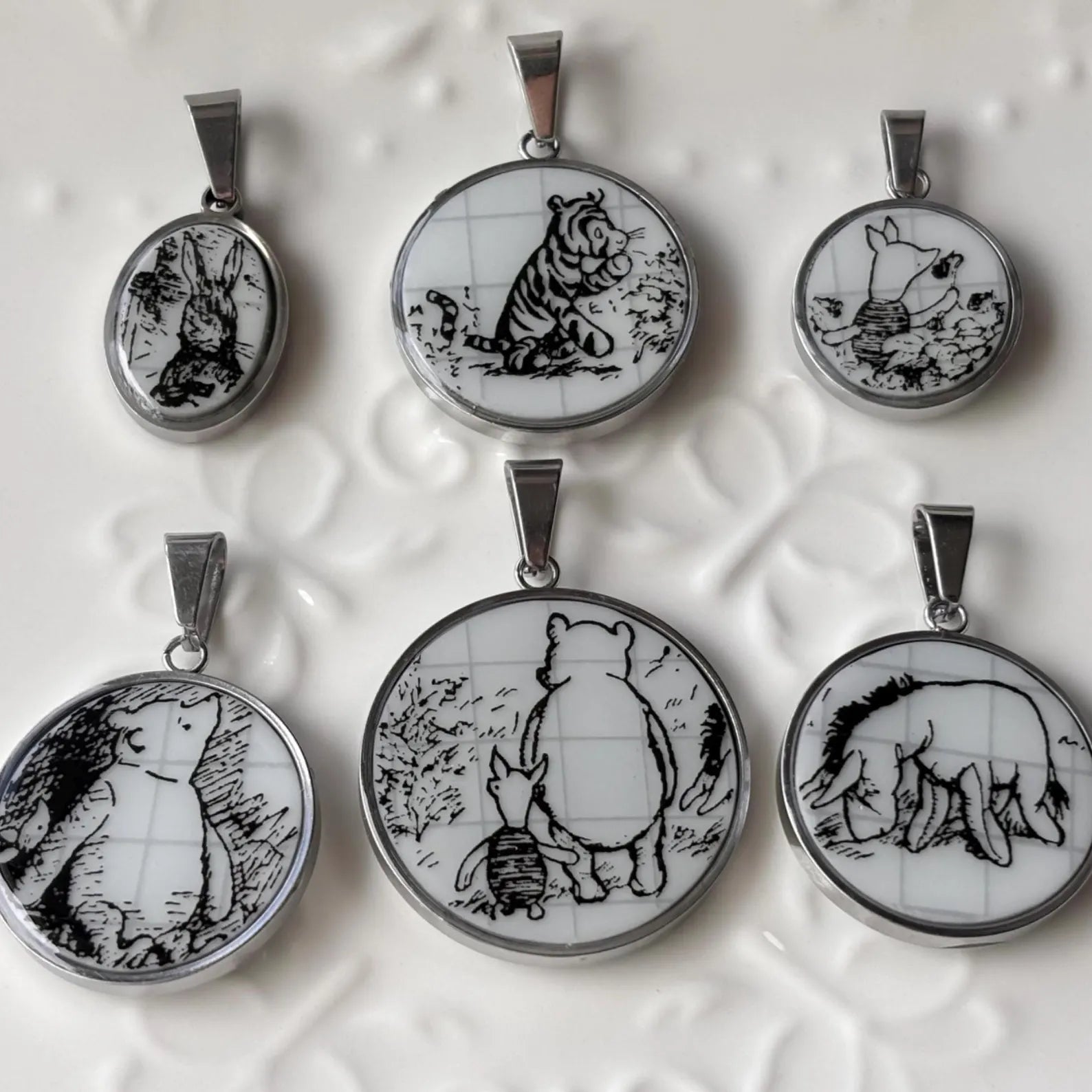 Set of six animal-themed pendants on a textured white background