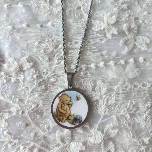 Necklace with a pendant featuring a bear design on a textured white background
