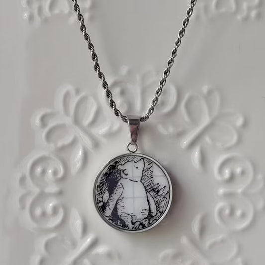 Necklace with a pendant featuring a bear design on an embossed white surface