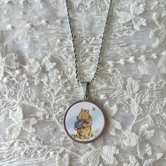 Necklace with a pendant featuring a cartoon character on a textured silver background