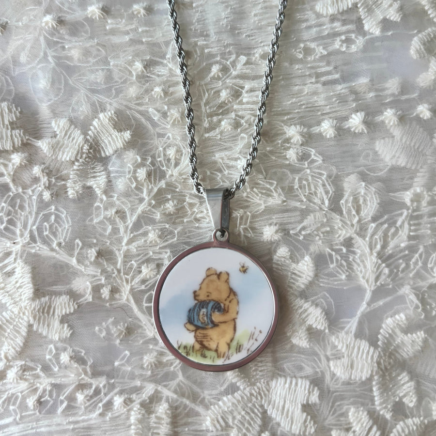 Necklace with a pendant featuring a cartoon character on a textured silver background
