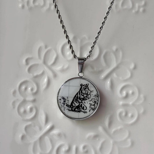 Necklace with a pendant featuring a black and white tiger design on a textured white background