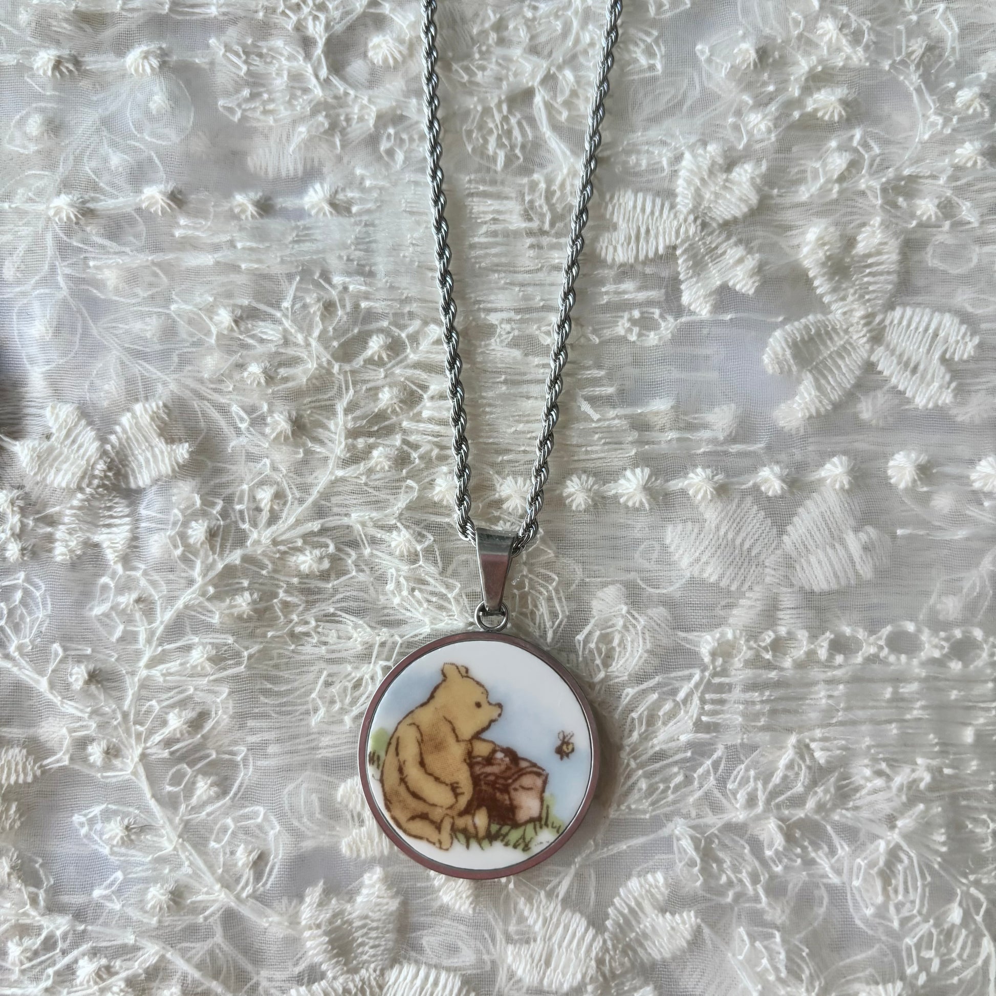 Necklace with a pendant featuring a bear design on a textured white background